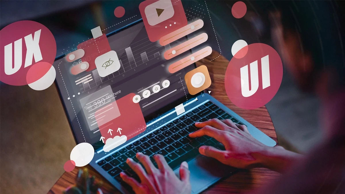 Person working on a laptop with floating UI and UX design elements, representing modern user interface design concepts for website redesign services in Chicago