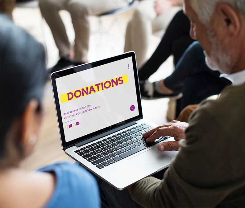 Person using a laptop with a “Donations” webpage on screen, highlighting how a nonprofit web designer creates user-friendly, mobile-optimized donation pages.
